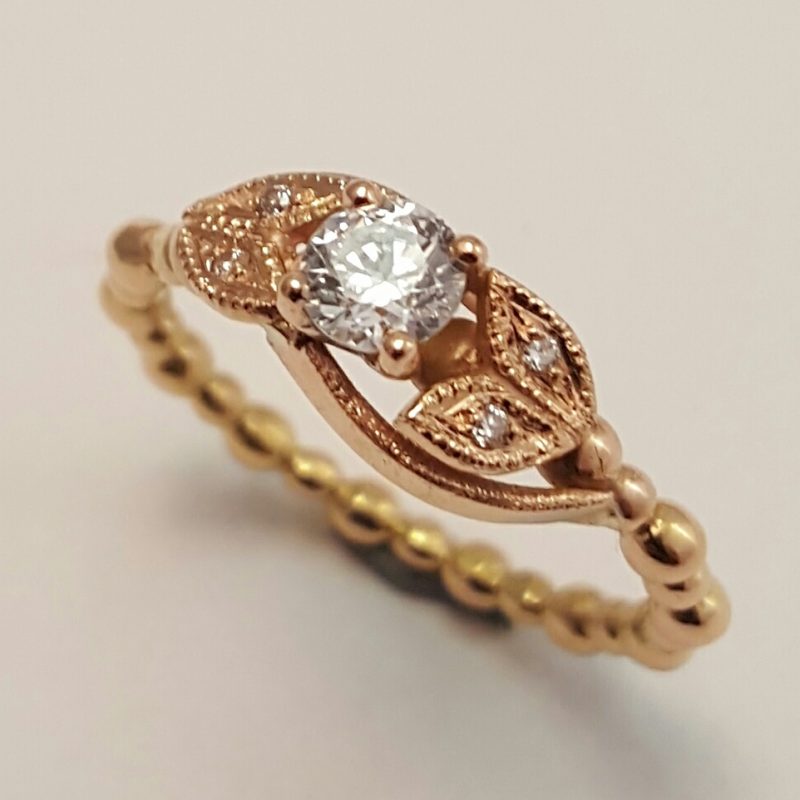 Package B: 18ct rose gold ring featuring a 4.5mm brilliant cut claw set diamiond. leaf detail with millgrian and pave set diamonds.