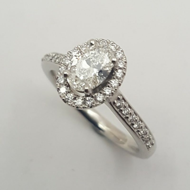 Package C: Platinum oval halo features a 0.50ct oval diamond with diamond mele.